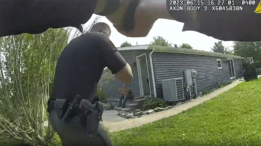 Two police officers approaching the house