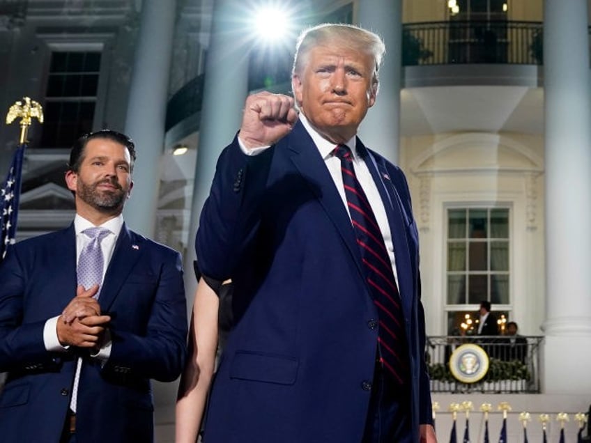 From left, Donald Trump Jr., President Donald Trump and first lady Melania Trump stand on