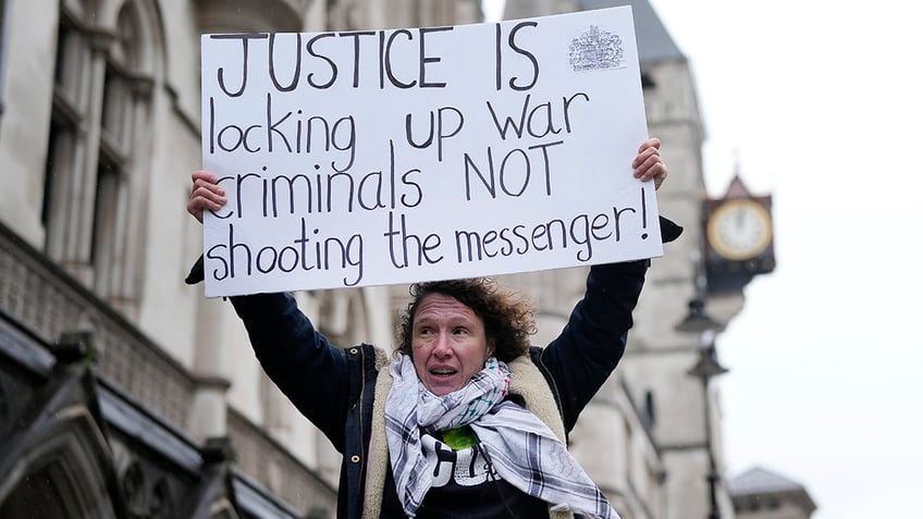 Assange supporter holds a sign