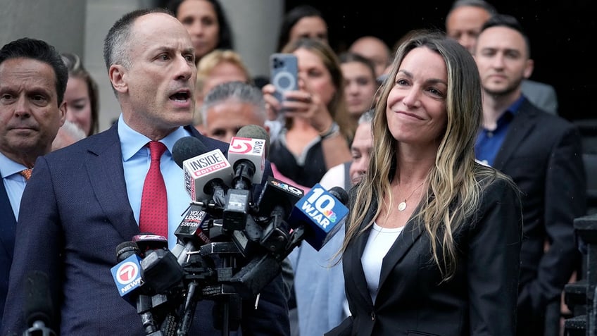 Karen Read smiles as defense attorney David Yannett speaks to reporters in front of Norfolk Superior Court