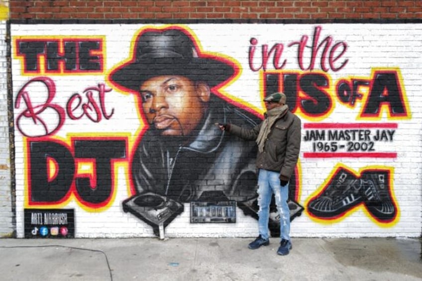 Local resident Jacob Rosthein poses before a mural paying tribute to late Run-DMC's Jam Ma