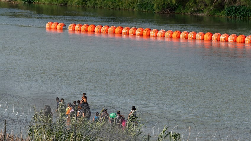 justice department sues texas over floating border barrier in the rio grande