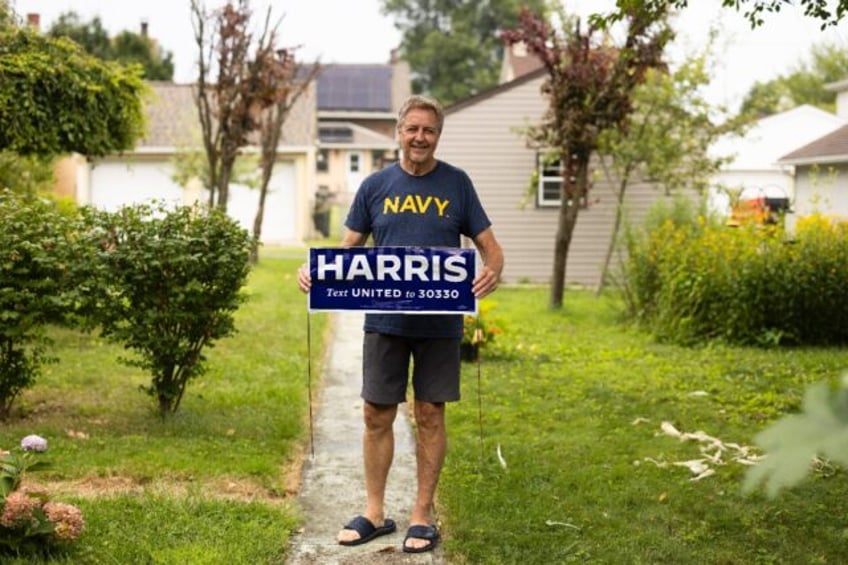 Bill Leiner, 70, shows off his DIY Kamala Harris campaign sign