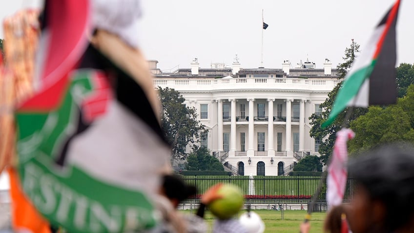 Demonstrators pass the White House during a protest against the visit of Israeli Prime Minister Benjamin Netanyahu