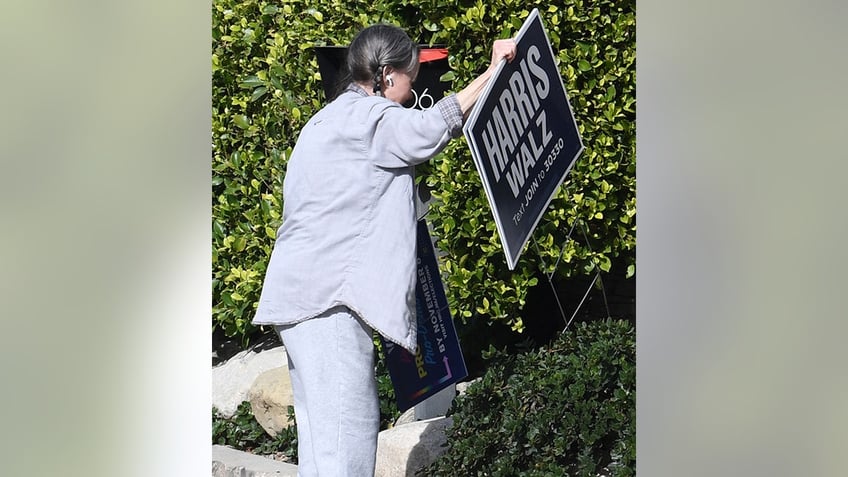 Sally Field holds up a Harris-Walz sign that was previously stuck in the ground