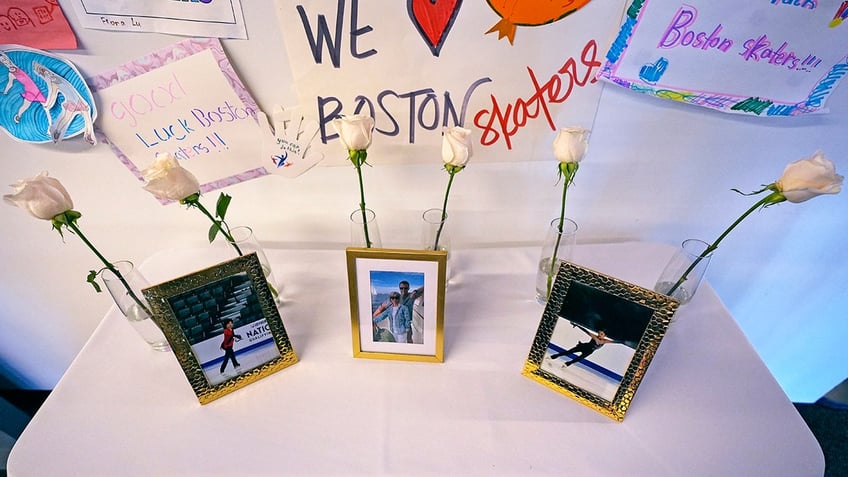 Six white roses and photographs of victims are displayed at The Skating Club of Boston,