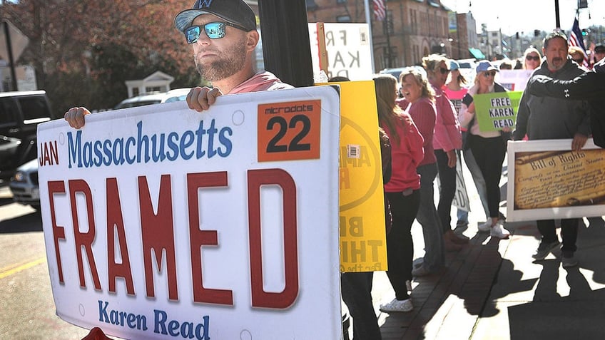 Matthew Pervier holds a sign he made in support of Karen Read outside of Norfolk Superior Court