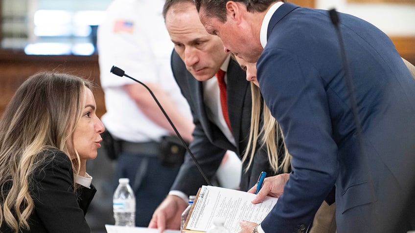 Karen Read speaks with lawyers in court during jury selection at Norfolk County Superior Court