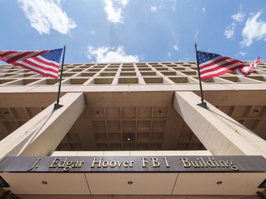 A bronze sign identifies the Federal Bureau of Investigation (FBI) headquarters building o