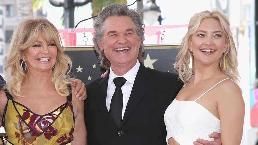 Goldie Hawn, Kurt Russell, and Kate Hudson posing togethter