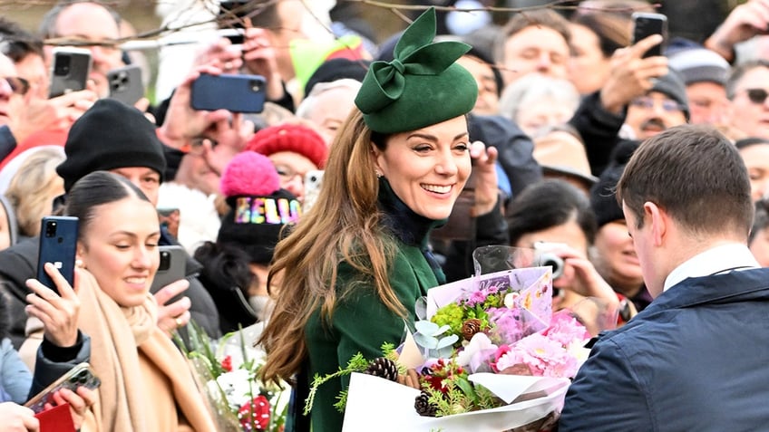 Kate Middleton smiling and holding flowers