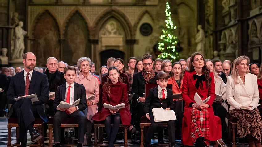 Kate Middleton sitting down at church wearing red alongside her family.