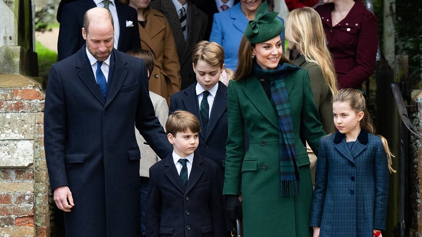 Kate Middleton smiling with her husband Prince William and their three children.