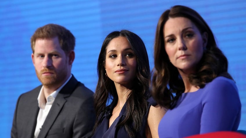 Prince Harry, Meghan Markle and Kate Middleton sitting together and looking serious