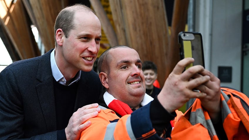 Prince William taking a selfie with a man