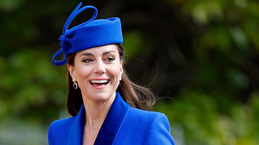A close-up of Kate Middleton wearing a cobalt blue suit and hat