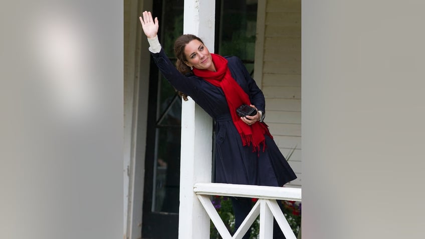 Kate Middleton waving and holding a camera