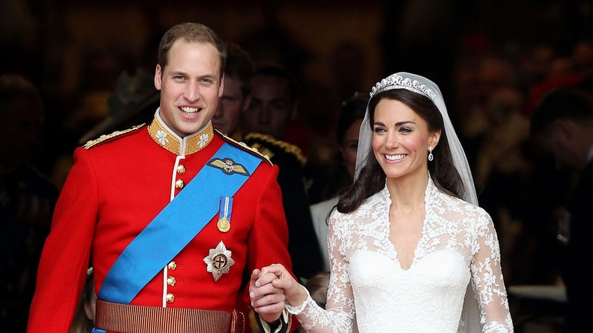 Prince Willim in a red suit and Kate Middleton in a bridal gown holding hands on their wedding day