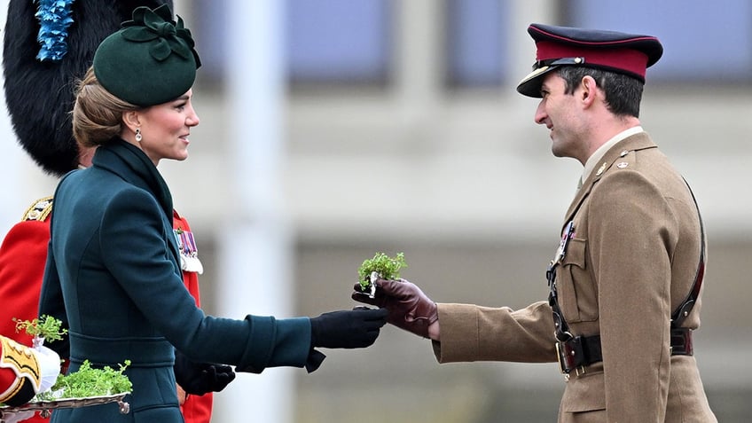 Kate Middleton handing out shamrocks to a soldier.