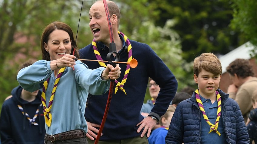 Princess Catherine shoots an arrow as Prince William laughs