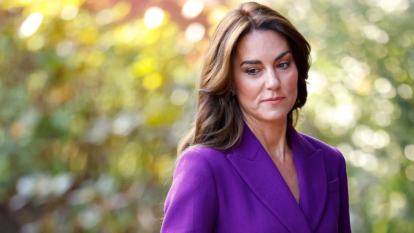 Kate Middleton wearing a purple blazer looking concerned