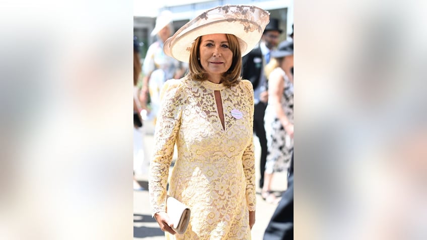 Carole Middleton wearing an ivory lace dress and matching hat.