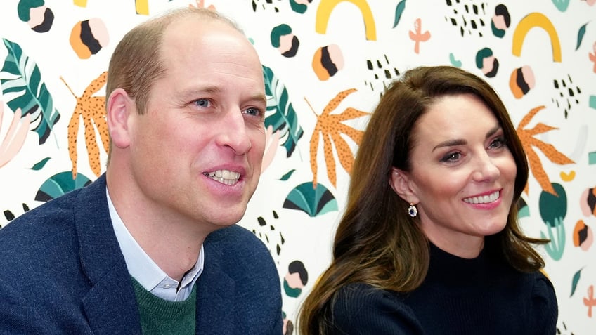 Prince William and Kate Middleton look off-camera adoringly in the 'Mentor Room' at the Open Door Charity.