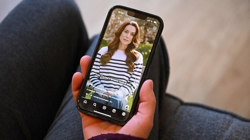 Someone holding a phone showing Kate Middleton making an announcement