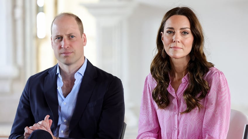 Prince William and Kate Middleton looking serious as they sit next to each other