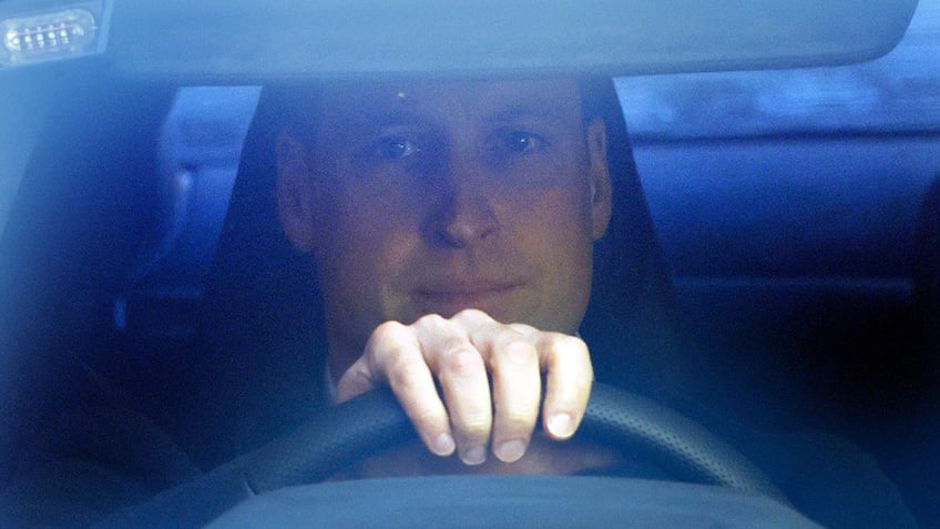 A close-up of Prince William driving his car