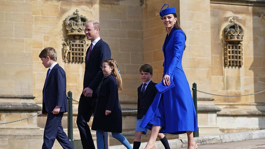 The Prince and Princess of Wales walking with their three children