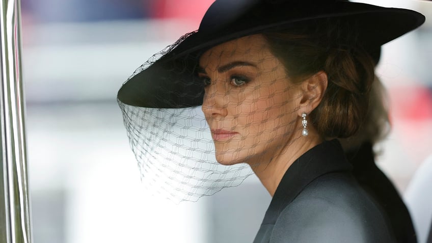 Kate Middleton wearing a black outfit looking somber