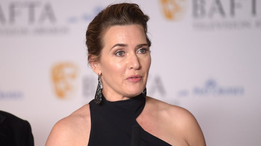 Kate Winslet in an asymmetrical halter dress on the carpet looks to be speaking