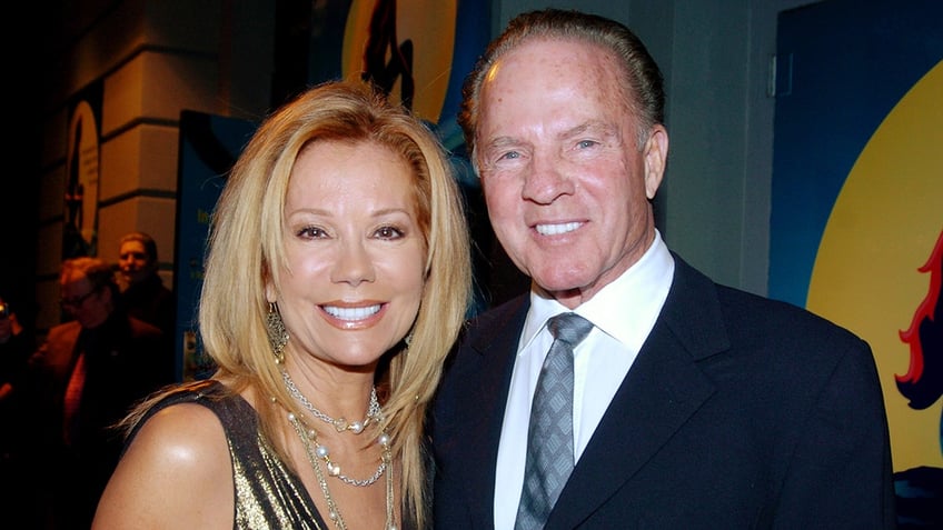 A close-up of Kathie Lee Gifford in a gold dress smiling next to Frank Gifford in a suit