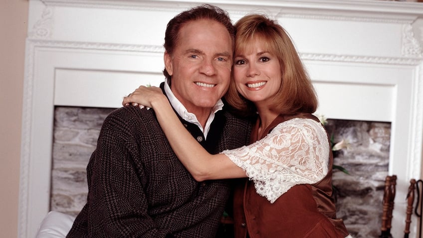 A young Kathie Lee Gifford embracing Frank Gifford inside their home