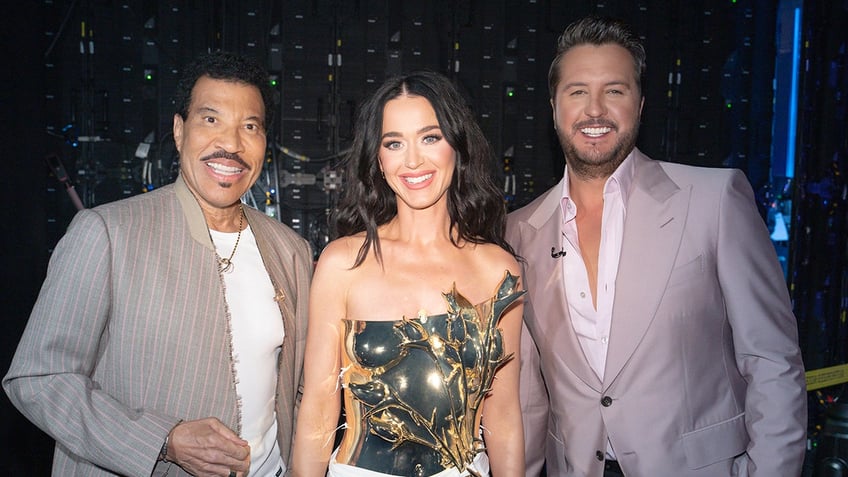 Singer Katy Perry wears metallic strapless dress at American Idol taping with Luke Bryan and Lionel Richie.