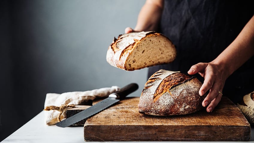 fresh baked sourdough bread being sliced