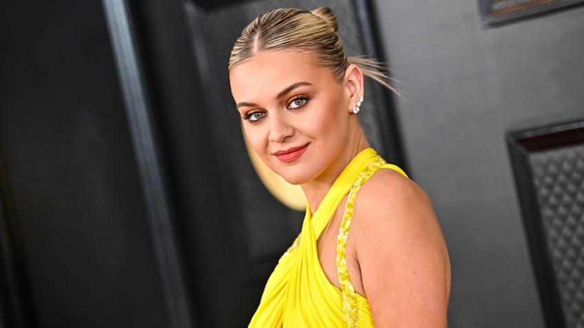 Kelsea Ballerini with an updo and a yellow dress on the Grammy red carpet