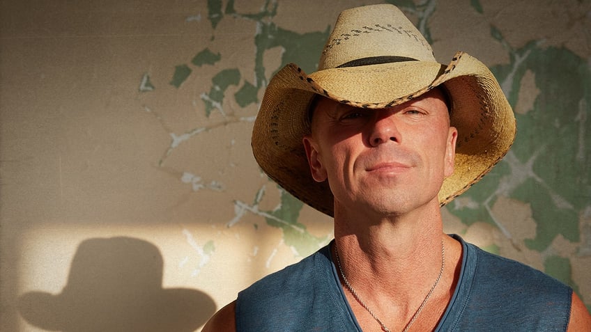 Kenny Chesney sports cowboy hat and cut-off shirt