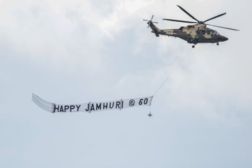 A Kenyan military helicopter carries a banner during the national celebration to mark Kenya's 60th anniversary of independence from Britain, known as Jamhuri Day