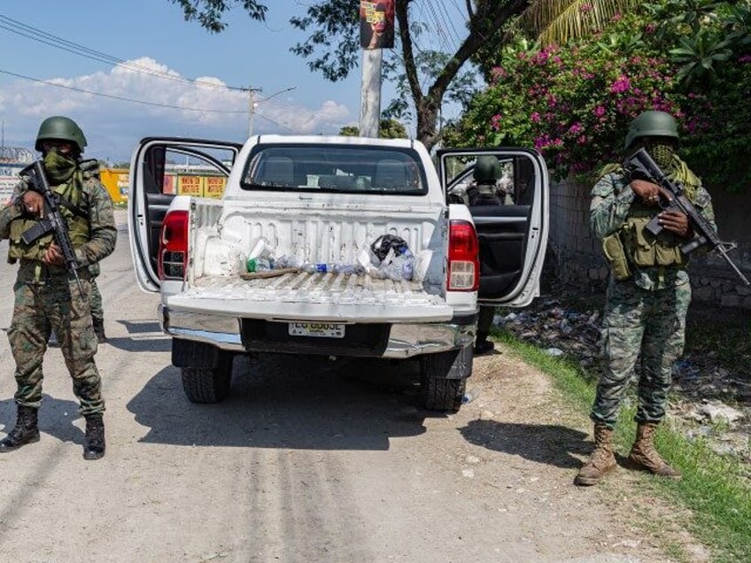 Haitian soldiers guard a checkpoint after armed gang members exchanged gunfire with police