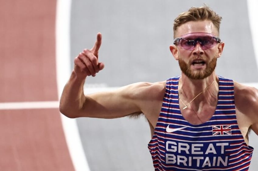 Britain's Josh Kerr reacts as he crosses the finish line to win the world indoor 3000m tit