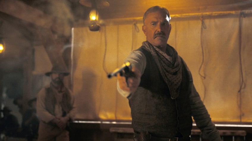 Actor Kevin Costner shoots a gun in country western drama