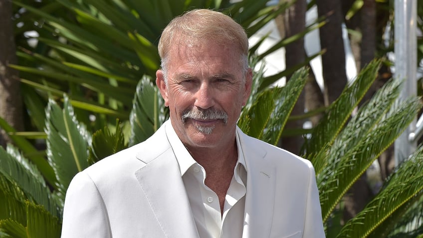 Actor Kevin Costner wears white suit at photo events in France.