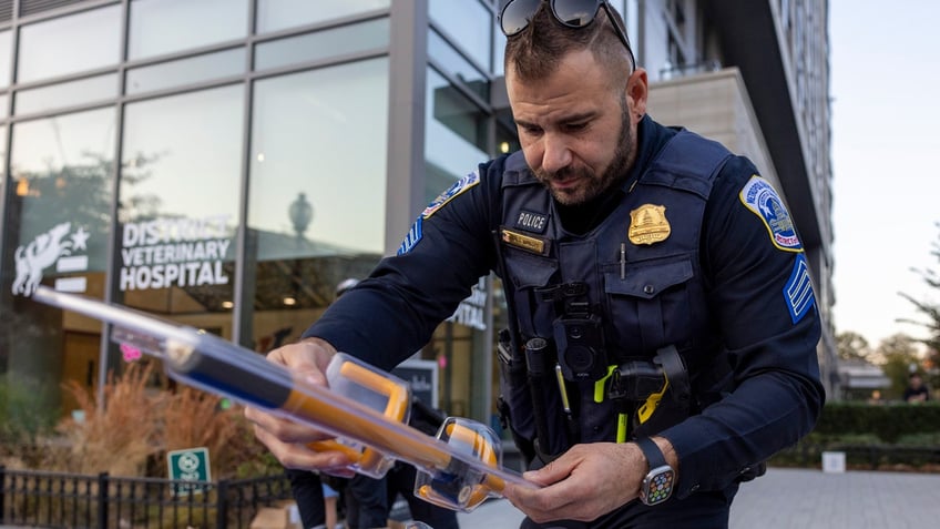 Metropolitan Police Department Sgt. Anthony Walsh sets out steering wheel locks at an anti-crime event in Washington