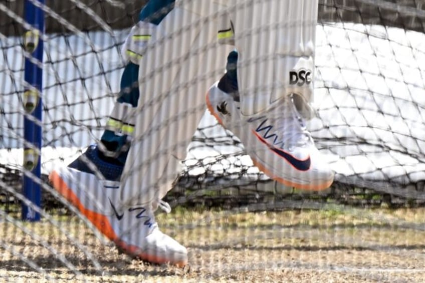 A dove symbol is seen on the shoe (R) of Australia's Usman Khawaja as he bats in the nets during a practice session at the Melbourne Cricket Ground