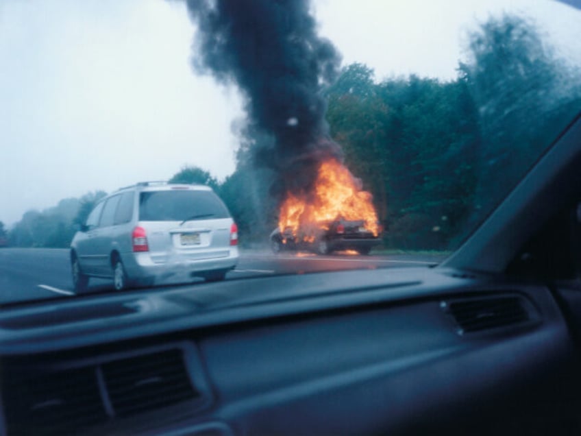 A vehicle on the highway is on fire.