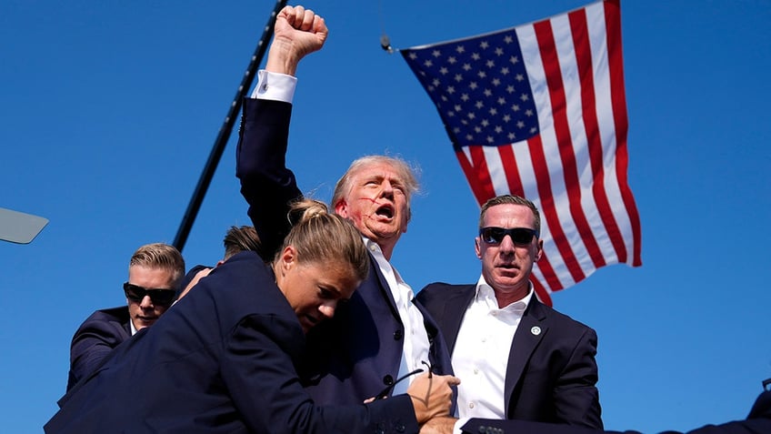 Republican presidential candidate former President Donald Trump is surrounded by U.S. Secret Service agents at a campaign rally