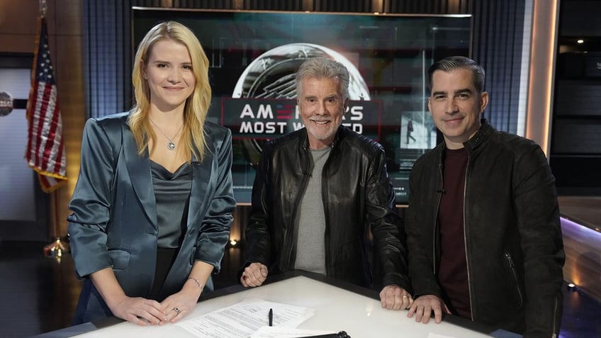 Elizabeth Smart smiling next to John Walsh and Callahan Walsh in front of a white table