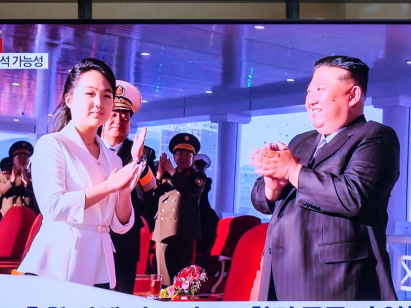 People look at a 24-hour Yonhap news TV broadcast at Seoul Railway Station showing a news
